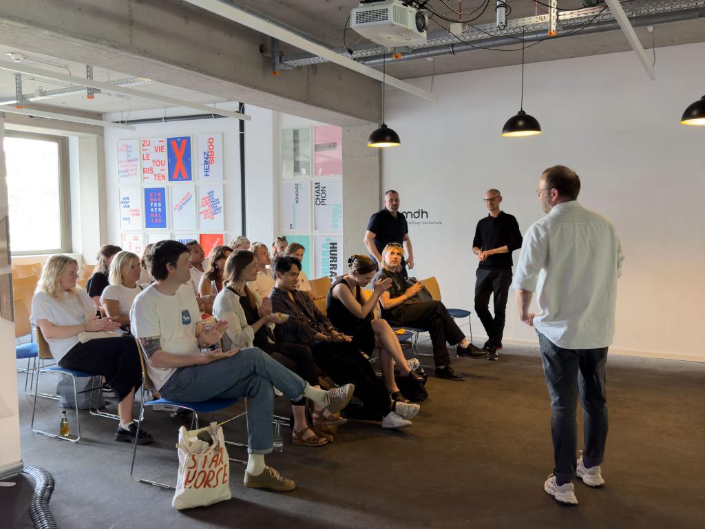 A busy classroom with students sitting in a group listening to three instructors.
