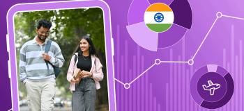 Two Indian international students walk on a path surrounded by green trees. They are framed by an illustrated background featuring the Indian flag and a line chart with points in an upwards trajectory.