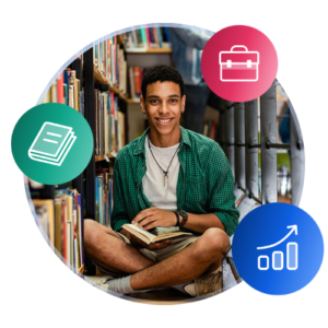A casually-dressed international student sits with a book on his lap in the stacks of a campus library.