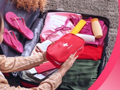 An international student adds a first aid kit to their suitcase.