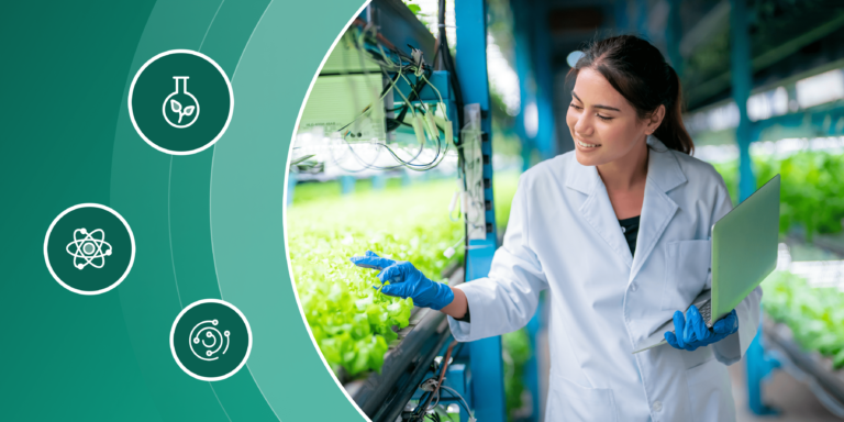 A young female scientist tends to sprouting plants in a greenhouse.