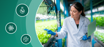 A young female scientist tends to sprouting plants in a greenhouse.